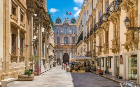 Via Roma a Trapani, un assaggio di cosa vedere a Trapani in un giorno: palazzi barocchi, negozi e un'atmosfera vivace.