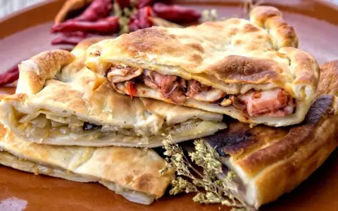 Pasticcio ripieno, un'idea su cosa mangiare a Gaeta. Ripieno di pesce e verdure, con peperoncini secchi sullo sfondo.