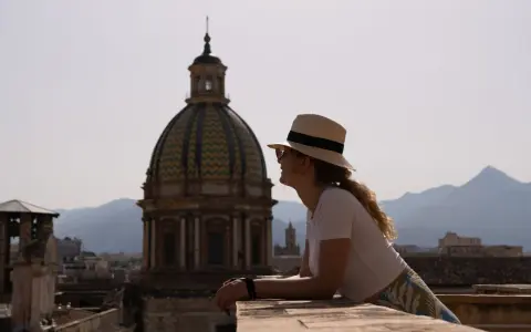 Vista panoramica di Palermo con una donna che ammira la cupola. Un'idea di cosa vedere a Palermo in 3 giorni.