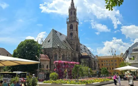 Piazza Duomo a Bolzano, con la cattedrale e aiuole fiorite. Perfetto per scoprire cosa vedere a Bolzano in un giorno.