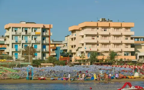 Edifici sul lungomare di Igea Marina, con molti ombrelloni e lettini sulla spiaggia. Le recensioni per hotel San Giorgio Savoia potrebbero menzionare questa vista.