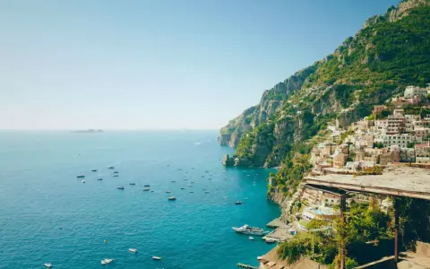 Positano, una delle perle delle regioni d'Italia, si affaccia sul mare blu con case colorate aggrappate alla scogliera.