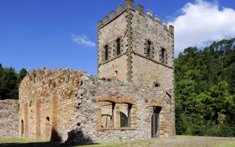 Rovine di un castello con torre merlata a Montecatini Val di Cecina, un luogo suggestivo da esplorare.