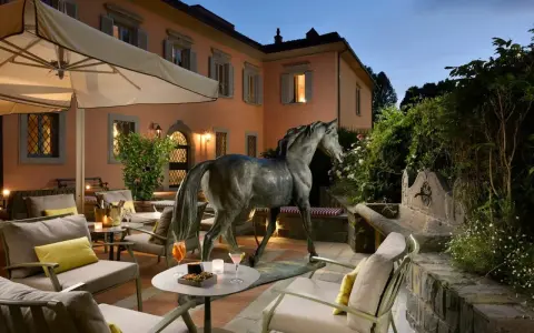 Terrazza con scultura equina e arredi eleganti, un invito al relax nella villa d'arte Pontassieve.