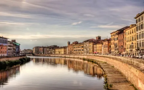 Lungarno a Pisa, con palazzi colorati che si specchiano nel fiume. Un'atmosfera da fiaba, tra Lucca e Pisa.