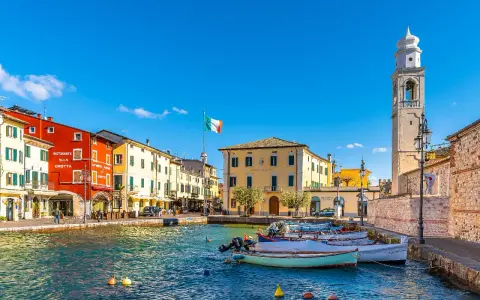 Lazise: cosa vedere nel borgo sul lago. Case colorate, porto con barche e campanile.