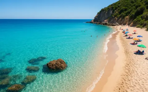 Spiagge del Lazio: sabbia dorata, acque cristalline e ombrelloni colorati sotto una scogliera verdeggiante.