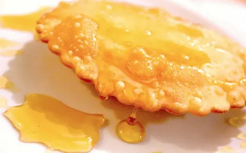 Dolce fritto, uno dei 5 piatti tipici della Sardegna, ricoperto di miele dorato.