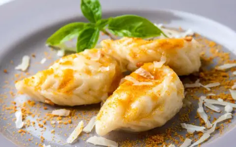 Malloreddus, un saporito cibo tipico sardo, conditi con formaggio grattugiato e una spolverata di zafferano.