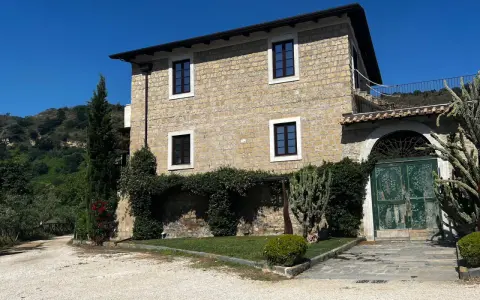 La Masseria del Carmine Maggiore, con le sue mura in pietra chiara e il verde rigoglioso, incanta sotto un cielo azzurro.