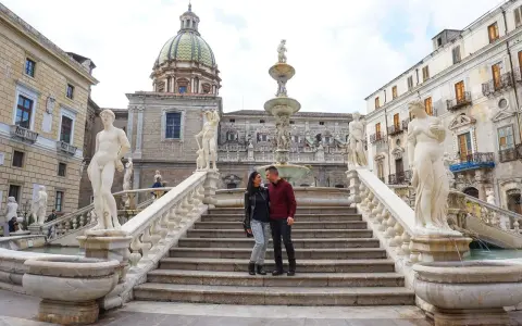 Coppia felice alla Fontana Pretoria, un'attrazione imperdibile per ogni itinerario a Palermo.