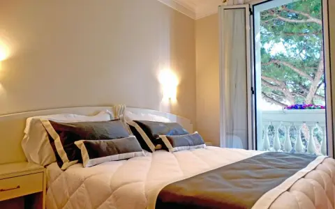 Camera accogliente con letto comodo e balcone fiorito. Ideale per chi cerca hotel Novecento Riccione recensioni positive.