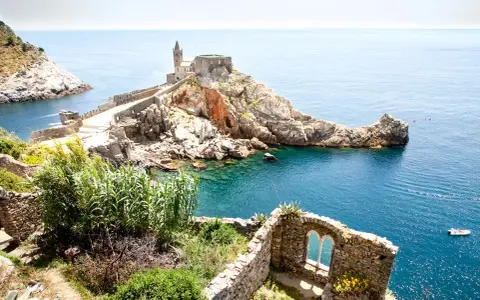 Chiesa di San Pietro a picco sul mare, un gioiello del portovenere centro storico, con acque cristalline e rovine antiche.