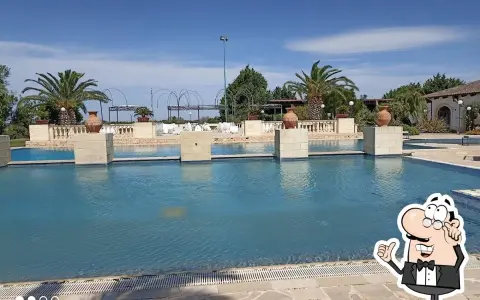 Piscina e palme a Tenuta Caradonna, un luogo ideale per rilassarsi. Le recensioni confermano la bellezza del posto.