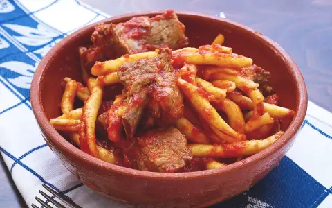 Un piatto di pasta fresca con ragù di carne, un sapore autentico di cibo calabrese.