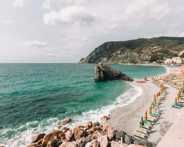 Una delle spiagge più belle della Liguria, con mare cristallino, scogli e un'infinità di ombrelloni colorati.