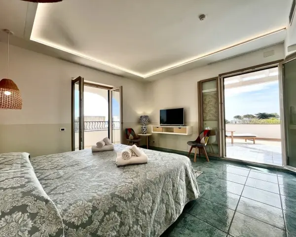 Camera da letto con vista mare al **hotel Lo Smeraldo Ventotene**. Letto matrimoniale, TV, balcone e arredi moderni.