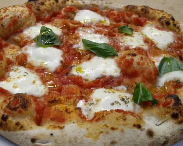 Pizza margherita con mozzarella filante, pomodoro e basilico fresco. Una vera casa matta, nota per la sua bontà.