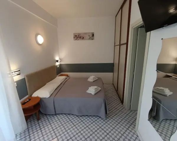 Camera accogliente con letto matrimoniale, biancheria fresca e un tavolino. Le recensioni per Hotel Le Terrazze Riccione confermano la comodità.