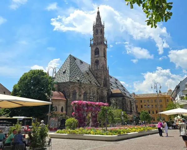 Piazza Duomo a Bolzano, con la cattedrale e aiuole fiorite. Perfetto per scoprire cosa vedere a Bolzano in un giorno.