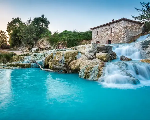 Cascate naturali con acqua turchese e un antico mulino in pietra. Un'oasi di pace, perfetta per un inverno nelle terme in Italia.