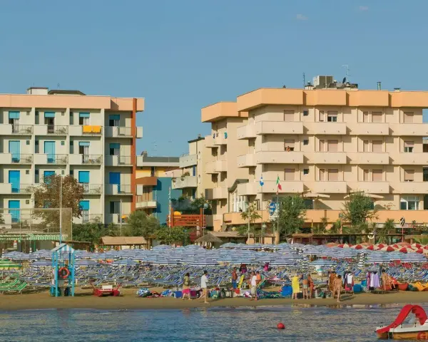 Edifici sul lungomare di Igea Marina, con molti ombrelloni e lettini sulla spiaggia. Le recensioni per hotel San Giorgio Savoia potrebbero menzionare questa vista.
