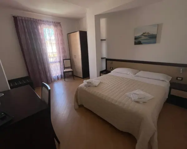 Camera accogliente nella pensione Scala a Portopalo, con letto comodo, armadio e scrivania.