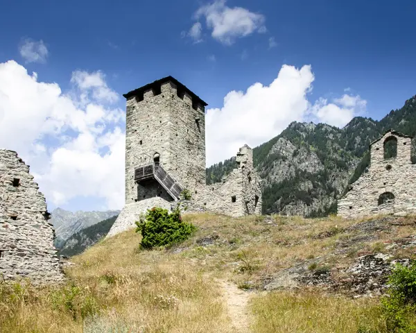 Rovine di un castello con torre in pietra, un invito a visitare la Valle d'Aosta.