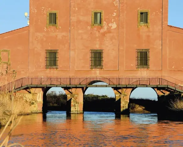 Antico edificio con ponte ad archi su un canale, un luogo suggestivo da scoprire a Castiglione della Pescaia.