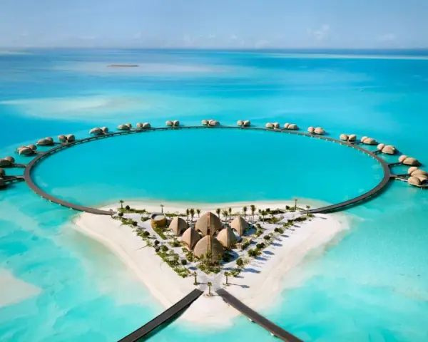 Resort circolare su un'isola tropicale, perfetto per le tue vacanze ad agosto. Case sull'acqua e sabbia bianca.