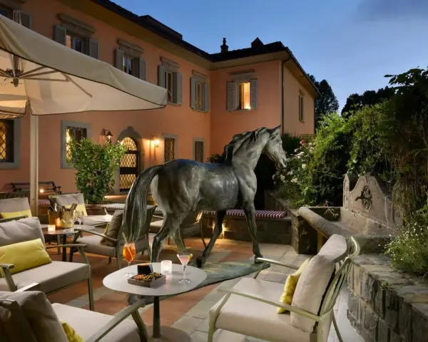 Terrazza con scultura equina e arredi eleganti, un invito al relax nella villa d'arte Pontassieve.