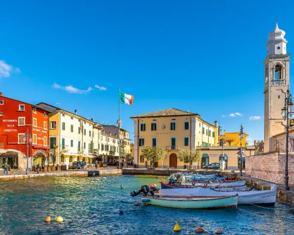 Lazise: cosa vedere nel borgo sul lago. Case colorate, porto con barche e campanile.