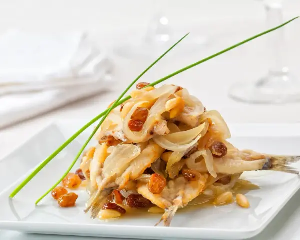 Sardine in saor, un classico delle ricette tipiche del Veneto, con cipolle, uvetta e pinoli.