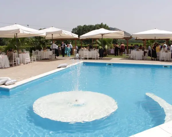 Un evento speciale alla Masseria Cardillo di Presenzano, con tavoli apparecchiati e ospiti vicino alla piscina con fontana.