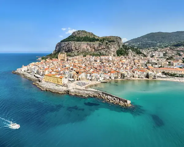 Vista aerea di Cefalù, con le sue spiagge siciliane orientali, il borgo arroccato e il mare cristallino.
