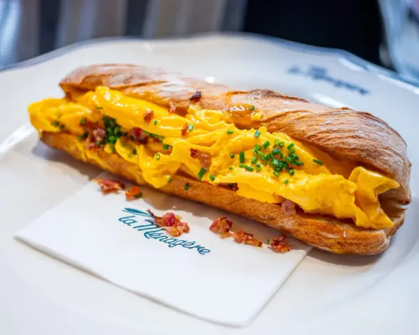 Panino con uova strapazzate, bacon croccante e erba cipollina. Un'ottima idea su cosa mangiare a Firenze per un pasto veloce e gustoso.