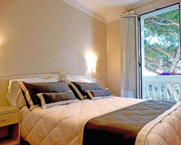 Camera accogliente con letto comodo e balcone fiorito. Ideale per chi cerca hotel Novecento Riccione recensioni positive.