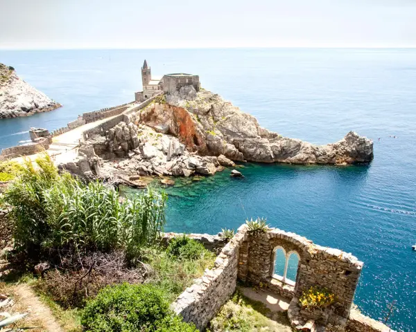 Chiesa di San Pietro a picco sul mare, un gioiello del portovenere centro storico, con acque cristalline e rovine antiche.