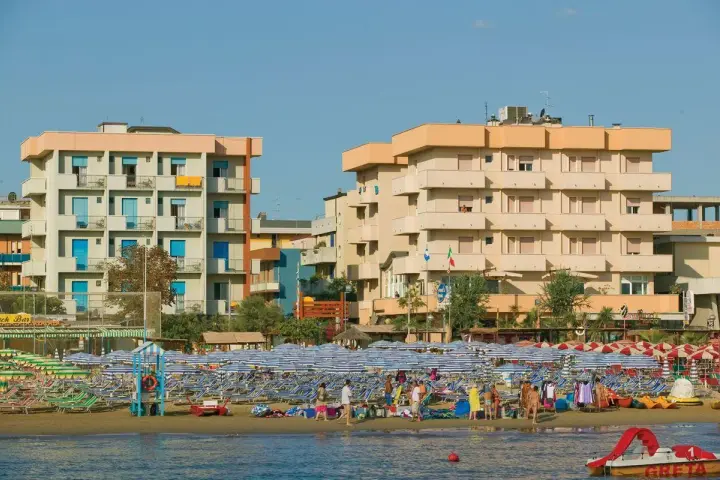 Edifici sul lungomare di Igea Marina, con molti ombrelloni e lettini sulla spiaggia. Le recensioni per hotel San Giorgio Savoia potrebbero menzionare questa vista.