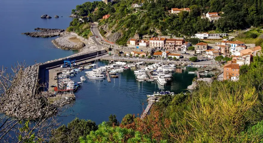 Maratea: un incantevole porto con barche ormeggiate, case colorate e vegetazione lussureggiante. Scopri cosa vedere nel suo centro storico.