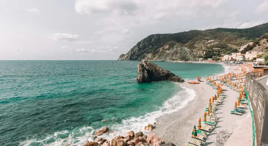 Una delle spiagge più belle della Liguria, con mare cristallino, scogli e un'infinità di ombrelloni colorati.