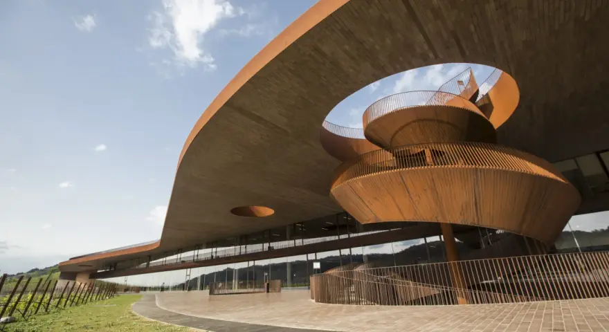 Edificio moderno con scala a chiocciola in corten, un esempio di cantine da visitare con architettura audace.