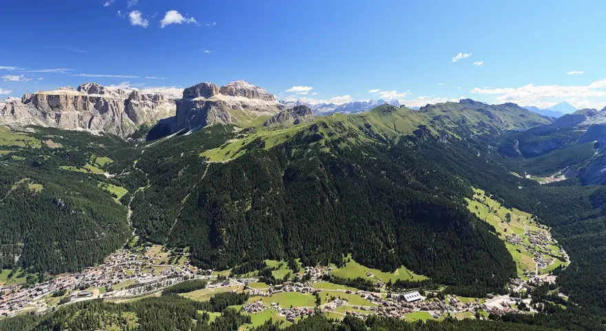 Panoramica delle Dolomiti, ideale per scoprire cosa vedere in Trentino in 3 giorni: valli verdi, boschi fitti e villaggi alpini sotto maestose cime rocciose.