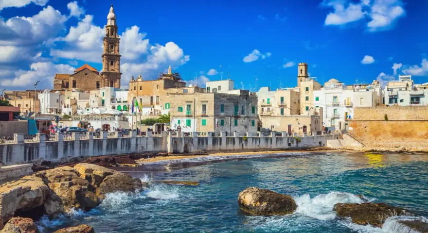 Vista sul mare di Bari Vecchia, con case bianche e torri che si affacciano sull'acqua cristallina. Un luogo incantevole da vedere.