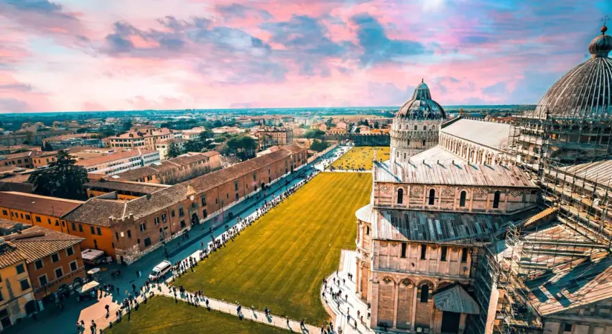 Un suggestivo itinerario Toscana 5 giorni inizia con la Piazza dei Miracoli a Pisa, con la sua cattedrale e il battistero sotto un cielo rosa.