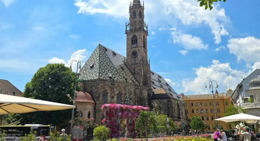 Piazza Duomo a Bolzano, con la cattedrale e aiuole fiorite. Perfetto per scoprire cosa vedere a Bolzano in un giorno.