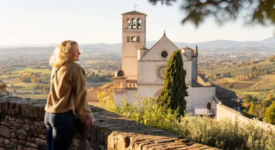Donna ammira il panorama di Assisi, con la Basilica di San Francesco in lontananza. Un ricordo di viaggio tra Assisi e Gubbio.