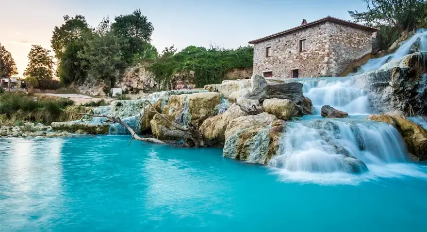 Cascate naturali con acqua turchese e un antico mulino in pietra. Un'oasi di pace, perfetta per un inverno nelle terme in Italia.