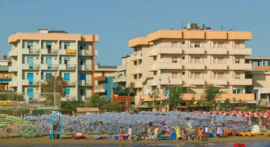 Edifici sul lungomare di Igea Marina, con molti ombrelloni e lettini sulla spiaggia. Le recensioni per hotel San Giorgio Savoia potrebbero menzionare questa vista.