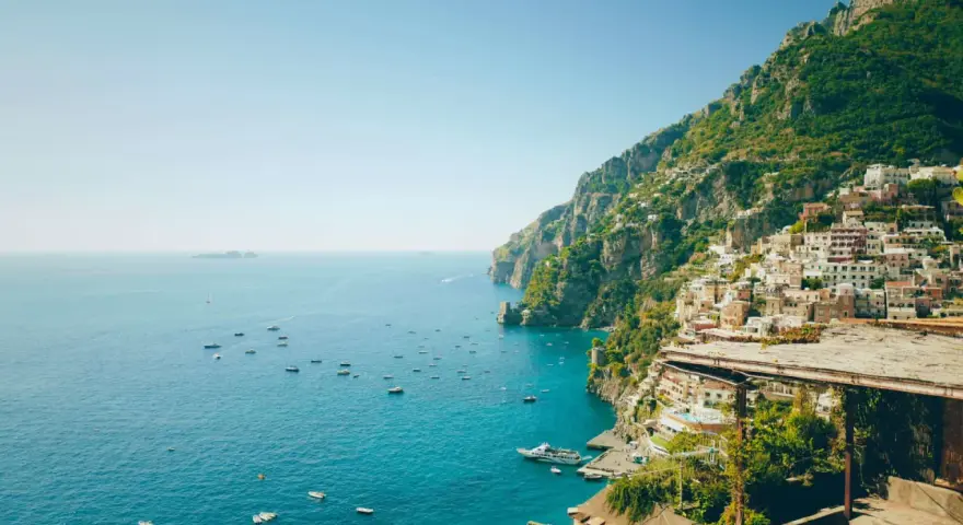 Positano, una delle perle delle regioni d'Italia, si affaccia sul mare blu con case colorate aggrappate alla scogliera.